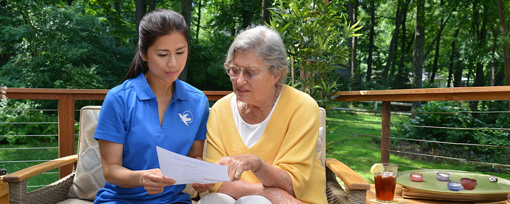 A Visiting Angels caregiver engaging with an elderly man outdoors, highlighting the warmth of in-home care services.