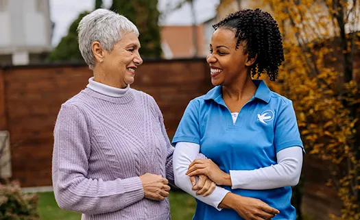 Visiting Angels caregiver with a senior female walking.