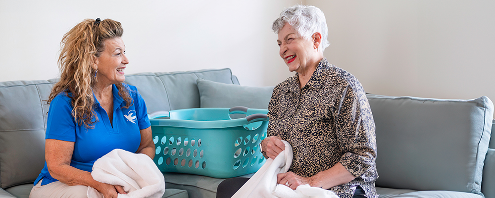 A Visiting Angels caregiver comforting an elderly woman with Alzheimer's, highlighting compassionate support in a peaceful home setting.