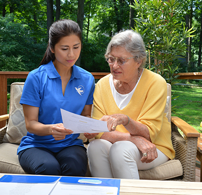 A Visiting Angels caregiver engaging with an elderly man outdoors, highlighting the warmth of in-home care services.