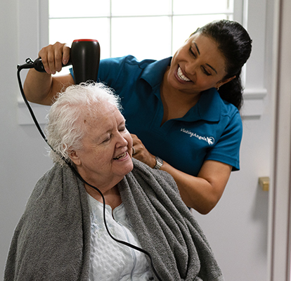 A Visiting Angels caregiver comforting an elderly woman with Alzheimer's, highlighting compassionate support in a peaceful home setting.