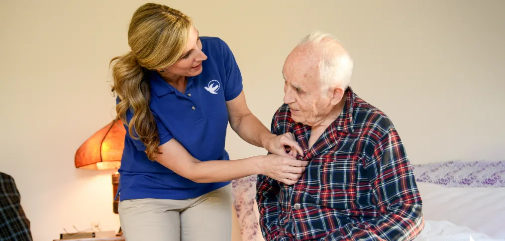 A Visiting Angels caregiver engaging with an elderly man outdoors, highlighting the warmth of in-home care services.
