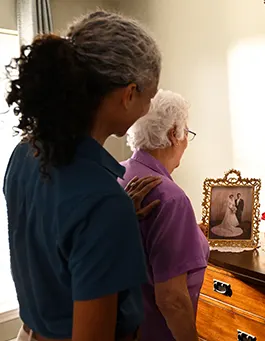 A female Visitng Angels senior home care provider assists an elderly woman with her hair.