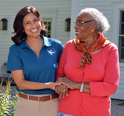 A Visiting Angels caregiver engaging with an elderly man outdoors, highlighting the warmth of in-home care services.