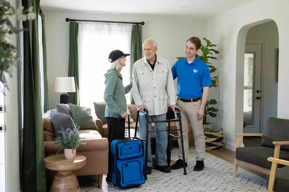 a man with alzheimers stands with a family member and a caregiver