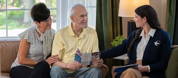 Home care coordinator conducting in-home assessment with senior man and wife.