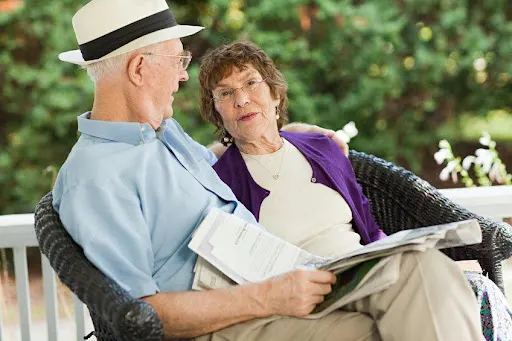 An elderly woman and an elderly man chatting.
