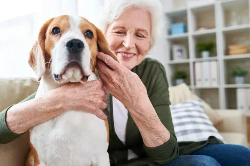 An older woman hugging her dog.